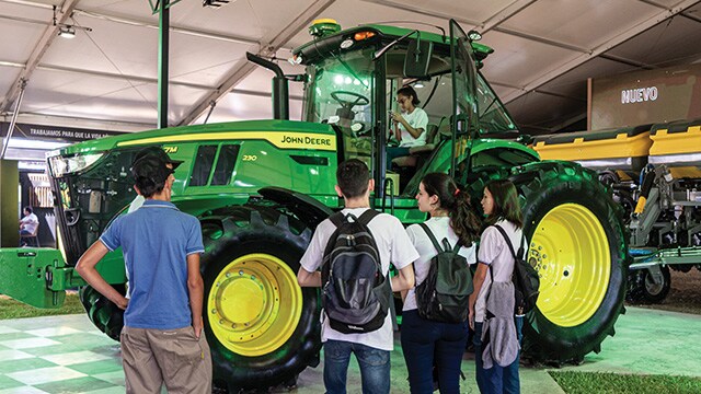 Una niña pequeña tomando una foto dentro de un tractor John Deere.