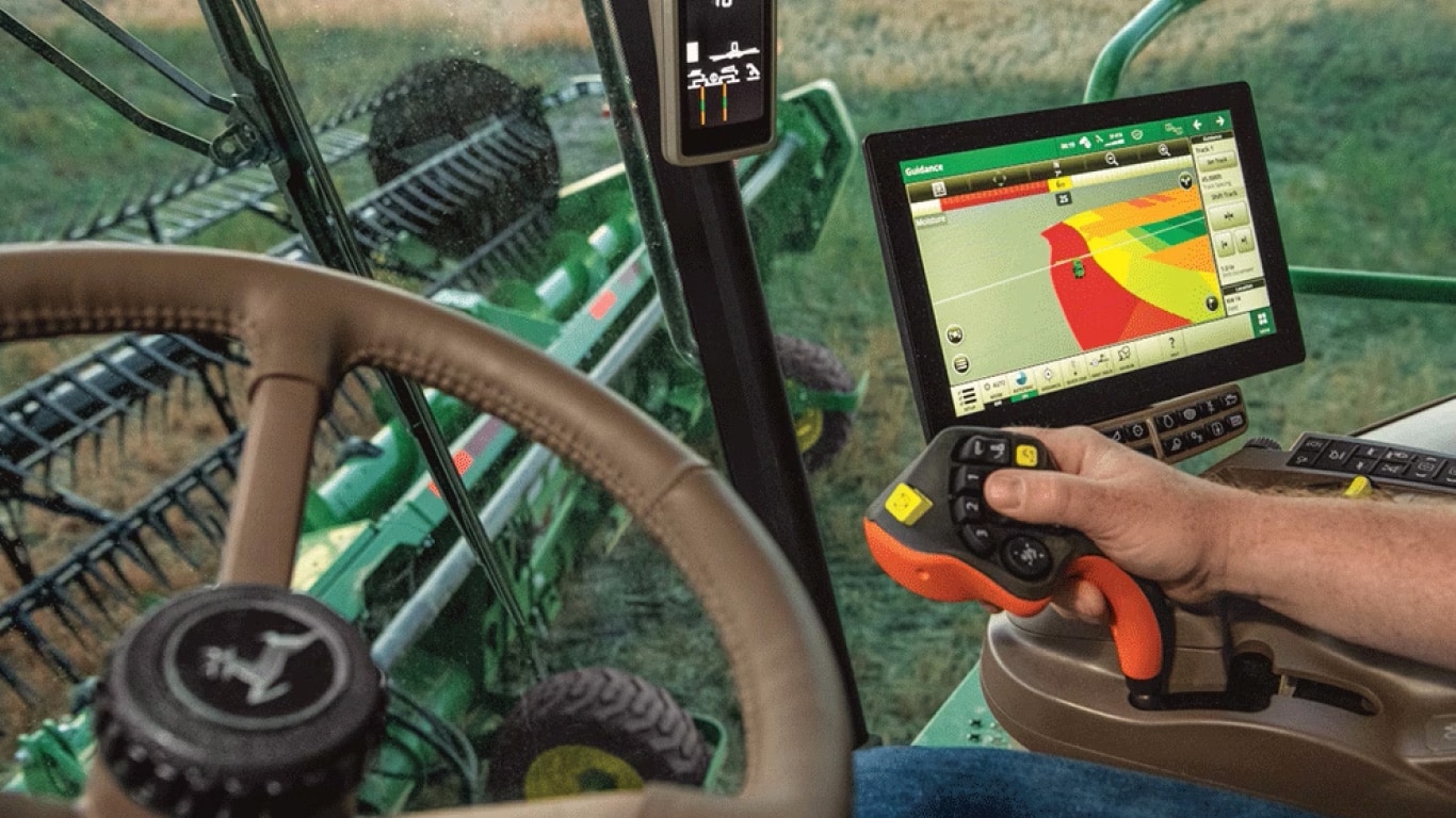 Vista desde el interior de la cabina de un tractor John Deere, con un monitor.