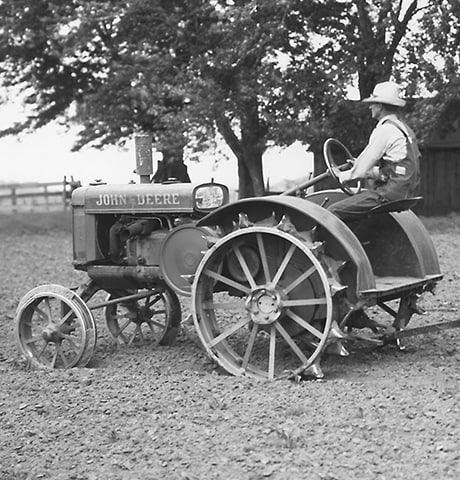 Tractor Histórico John Deere de Uso General "GP" tira de un Rotocultivador John Deere n° 7 en el campo