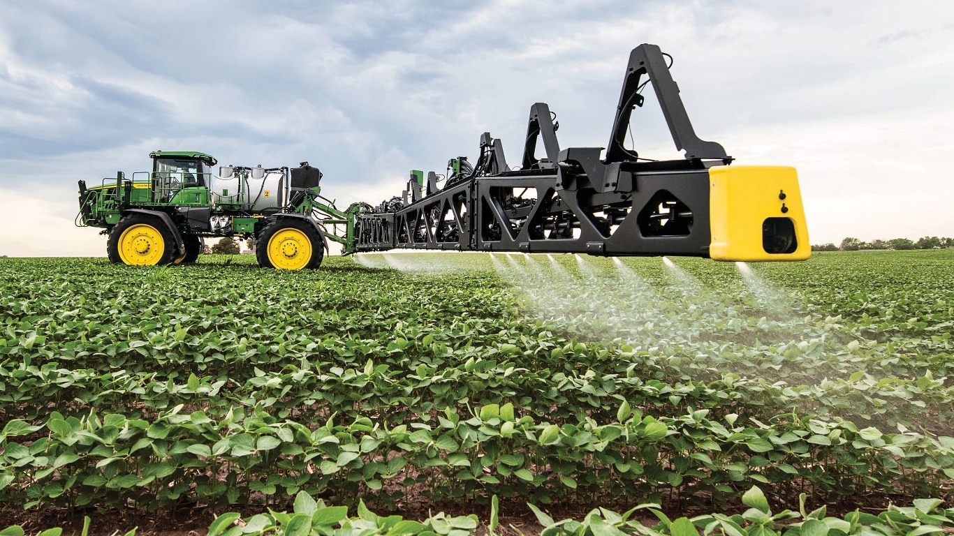 Vista de primer plano de la pluma del pulverizador John Deere en un campo abierto.