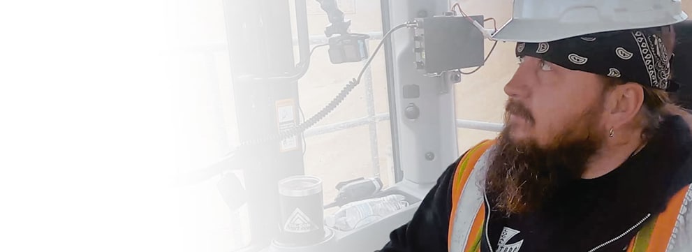 Bob Haun dentro de una cabina operando un equipo con un casco protector