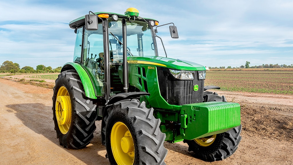 Tractor John Deere 0 km en un lote agrícola, vista lateral.