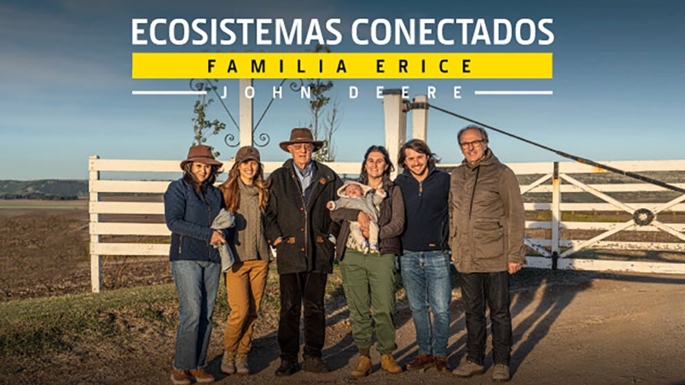 Una familia parada frente a una cerca en su granja. Graphic title: ecosistemas conectados familia erice