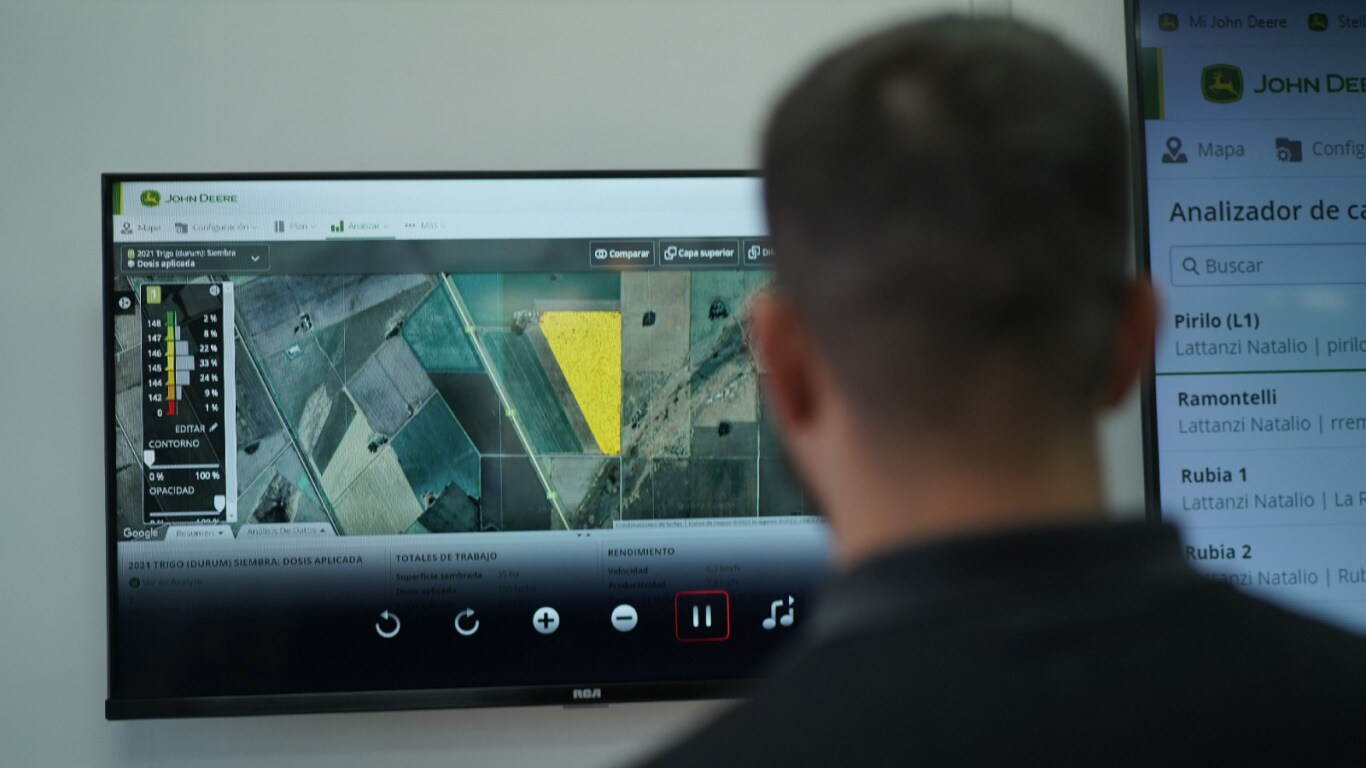 John Deere conecta el campo con el futuro - Un hombre de espaldas mirando una pantalla con la imagen del Centro de Operaciones.