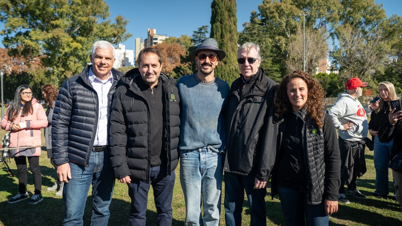 Grupo de asistentes posa para una fotografía grupal al aire libre durante una actividad institucional en un parque.