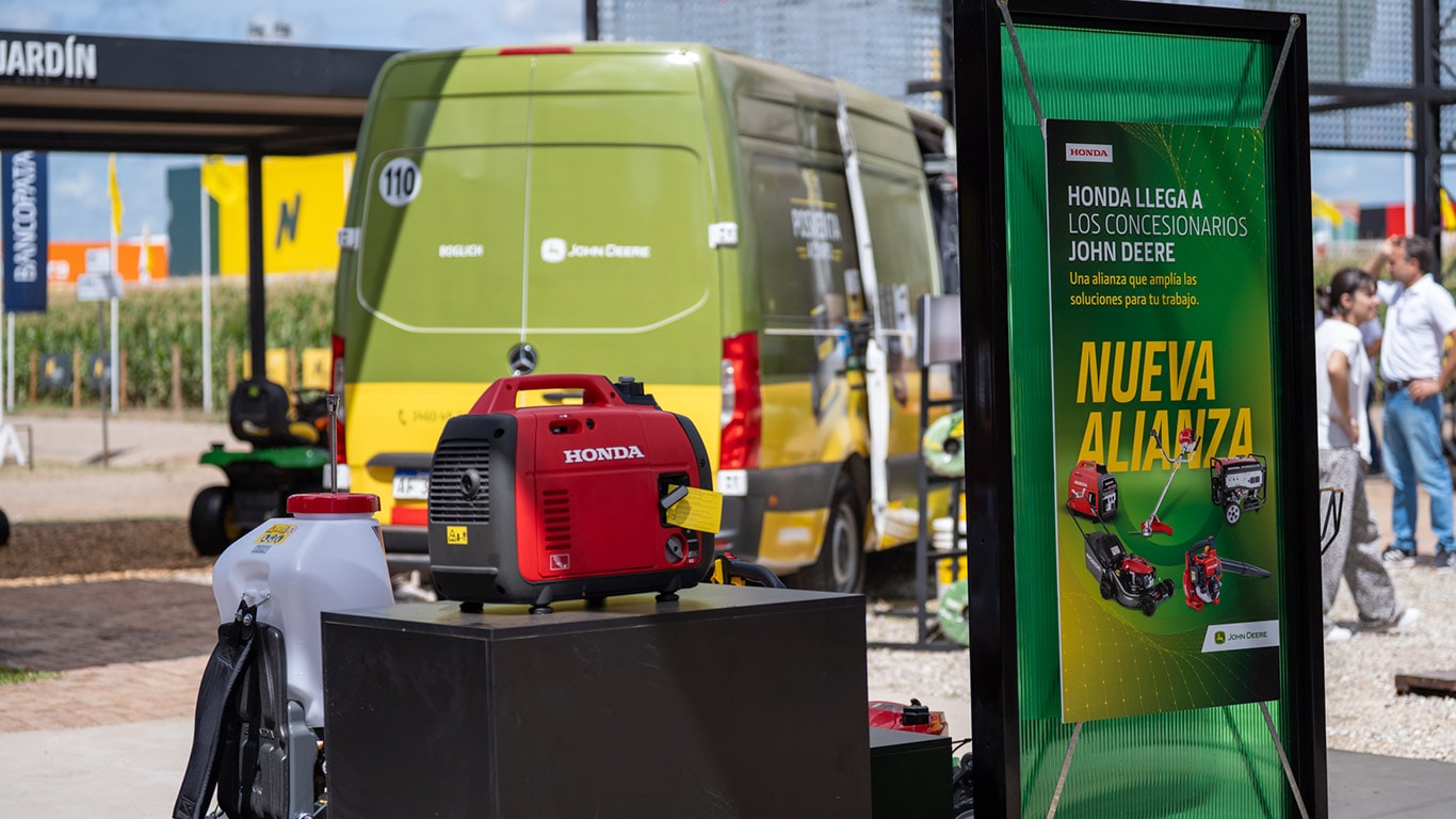 Dispositivo Honda sobre una estructura negra con una furgoneta de Posventa al fondo, en una feria.