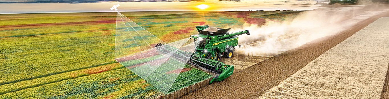 Cosechadora John Deere S7 en el campo, con símbolos de satélites alrededor, demostrando la conectividad.