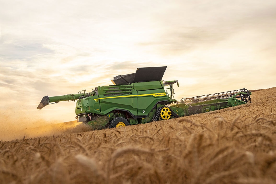 Cosechadora John Deere X9 1000 trabajando en campo de trigo, destacando su alta capacidad y eficiencia en cosecha.